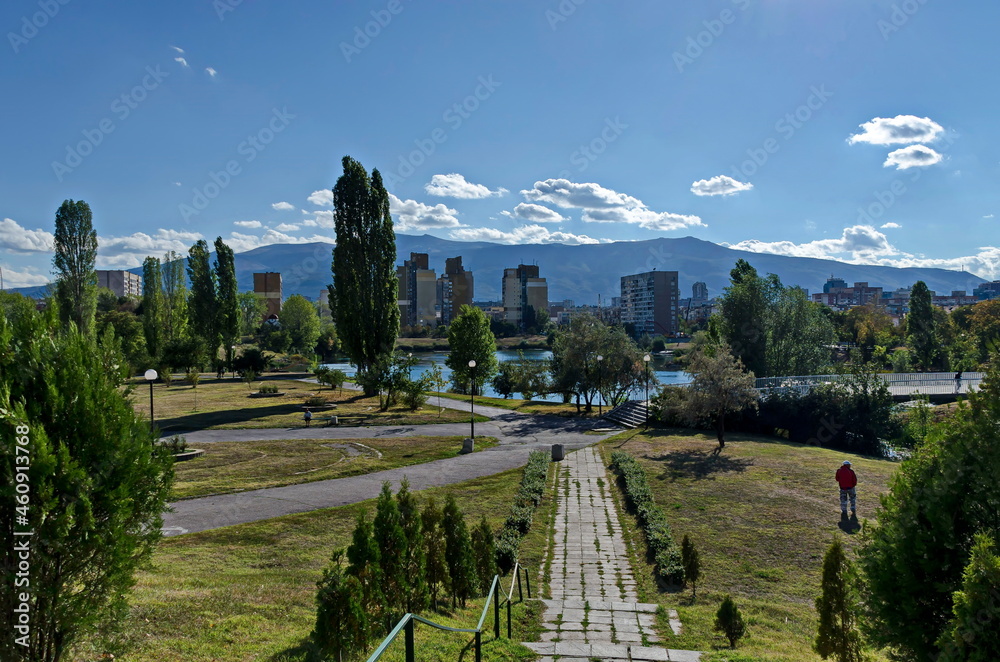 Autumn panorama of part of the neighborhood by the lake with green trees, shrubs and sunburned grass, Drujba, Sofia, Bulgaria