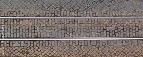 Metal tram rails on the cobblestone pavement. View from above