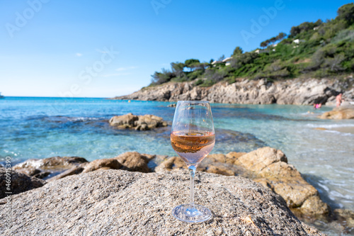 Summer time in Provence, glass of cold rose wine on sandy beach and blue sea near Saint-Tropez, Var department, France photo