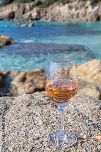 Summer time in Provence, glass of cold rose wine on sandy beach and blue sea near Saint-Tropez, Var department, France