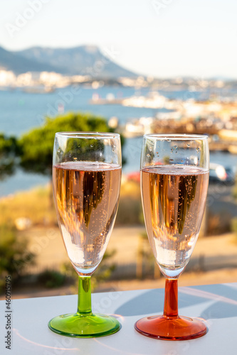 Summer party, drinking of French champagne rose sparkling wine in glasses with view on fishermen harbour of Toulon, France