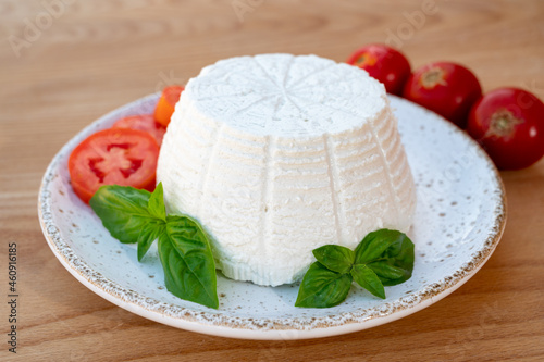 Cheese collection, white Italian soft cheese ricotta served with fresh tomatoes and basil