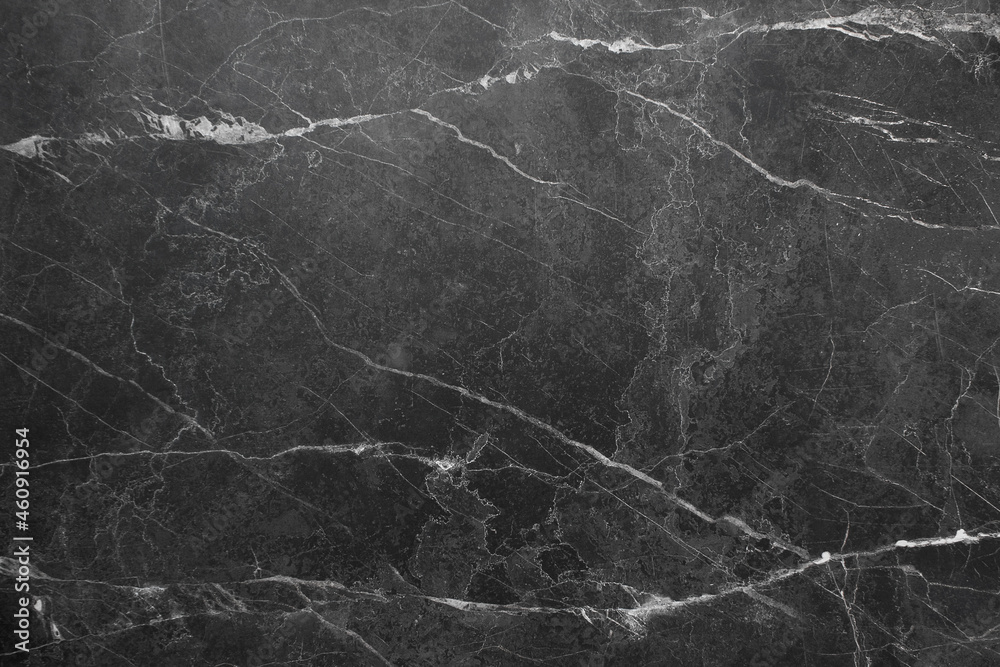 A black, marble wall with stripes. Dark background with marble texture.