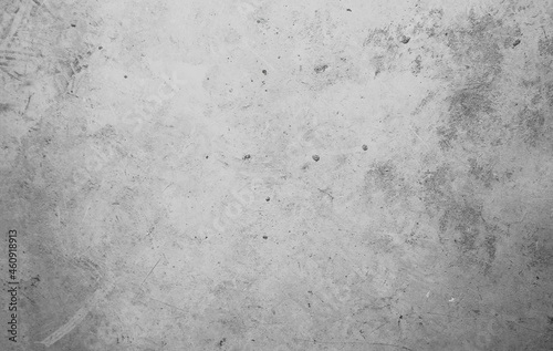 A concrete wall with dots and scuffs of gray color. Grey background with cement texture.