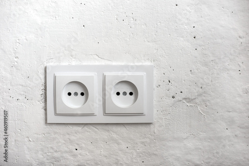 Two white European sockets on a white wall
