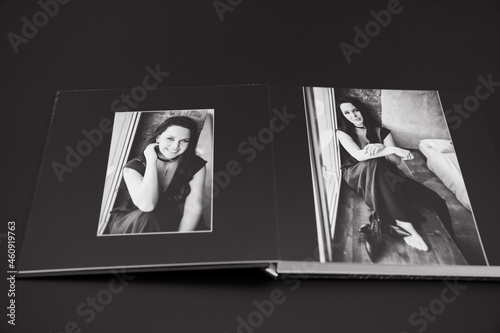 open photobook from a photo shoot of an attractive woman on a black background. 