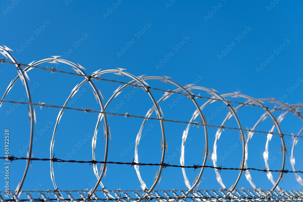 highly protected prison wall with barbed wire fence. steel grating fence  Stock Photo | Adobe Stock