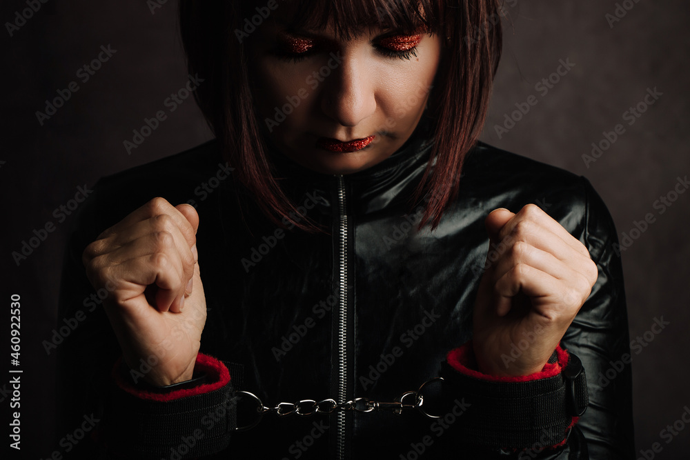 Close Up of Woman with black latex dress and Hand Cuffs. - obrazy, fototapety, plakaty 