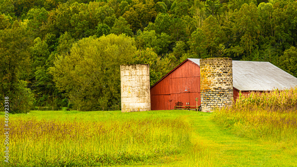 Obraz premium Red barn with two silos.