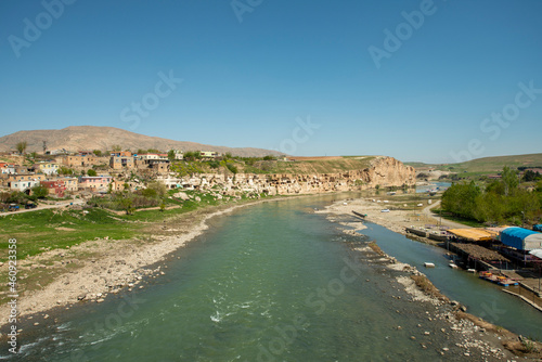 Waters of the Tigris river as it passes through the city of Hasankeyf with a cliff full of caves in an area of Mesopotamia photo