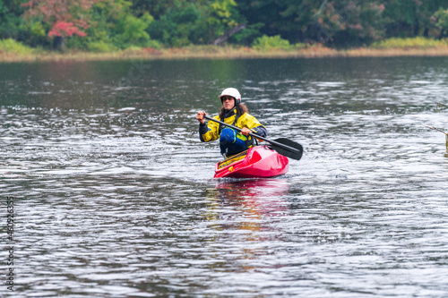 A solo canoeist practices stroke techniques on a rainy fall day as part of a “moving water” paddling course. Shot on the Madawaska River an iconic paddling destination in Eastern Ontario, Canada.