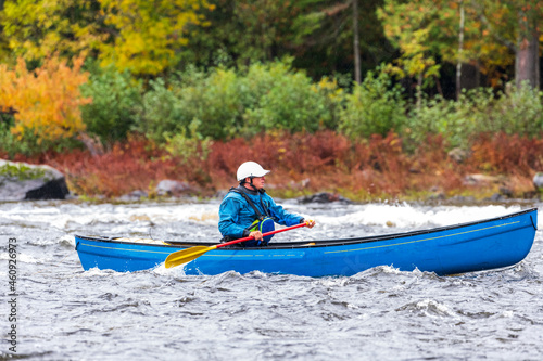 A solo canoeist practices stroke techniques on a rainy fall day as part of a “moving water” paddling course. Shot at Palmer Rapids on the Madawaska River an iconic paddling destination in Eastern Onta