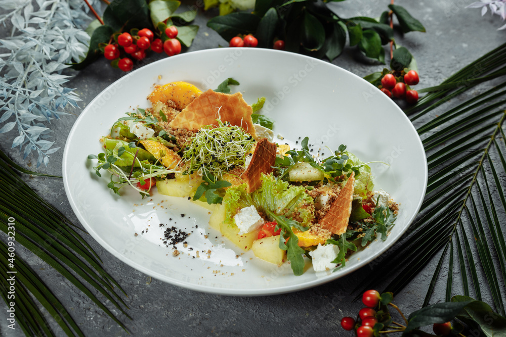 Summer diet salad with leaves of lettuce, watermelon, peach and feta cheese. On a light blue background copy space Summer diet salad with leaves of lettuce, watermelon, peach and feta cheese. On a light blue background copy space