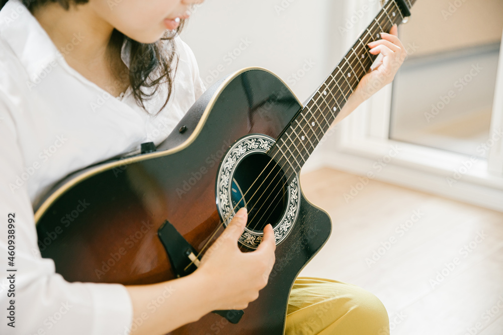 ギターを奏でる女性 ギターを演奏する女性 部屋でギターを演奏する人 