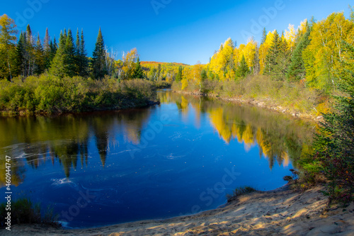 Fall colors in the Canadian forest with lake in the province of Quebec