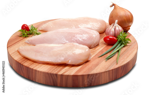 Peito de frango cru, sobre tábua de madeira redonda no fundo branco para recorte.