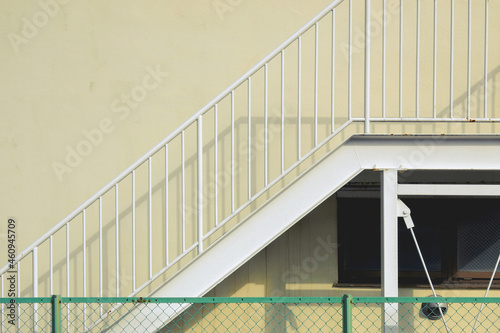 Yellow walls, metal stairs and windows, and a green fence / 黄色い壁に金属の階段と窓と緑の柵