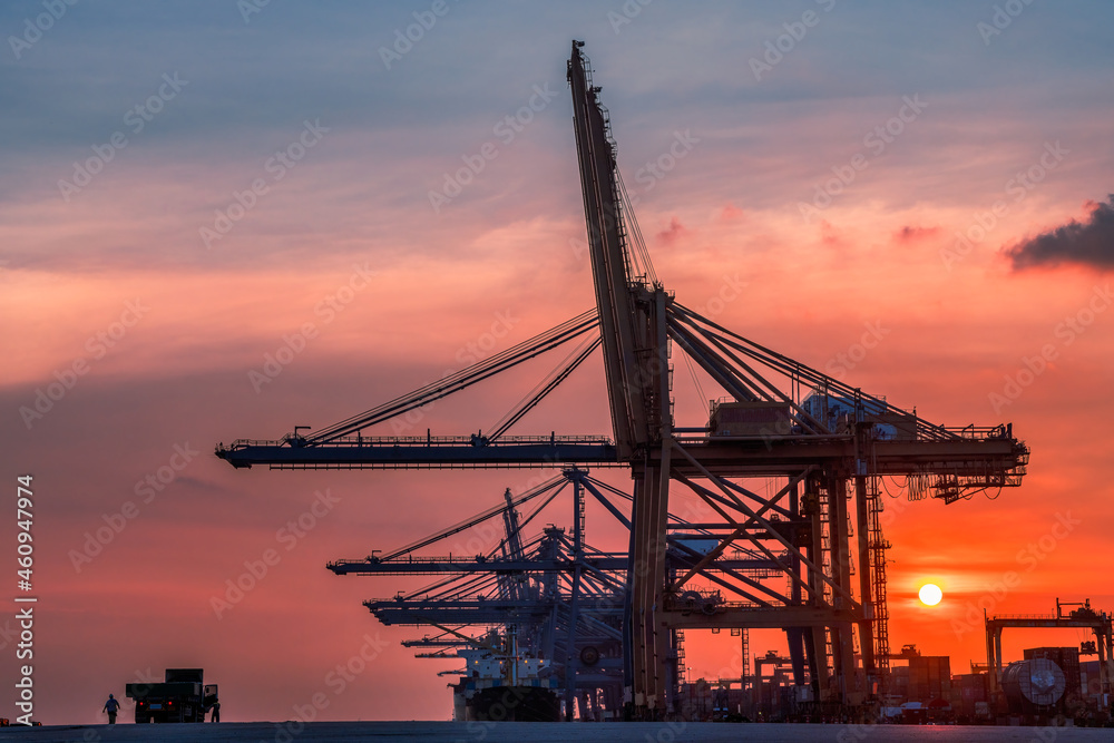 Container crane cargo freight ship with working crane loading bridge containers in shipyard at dock yard for logistic import and export transportation background.