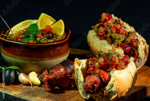 traditional chilean choripan and bowl with pebre, roast from national holidays in chile, chorizo sandwich photo