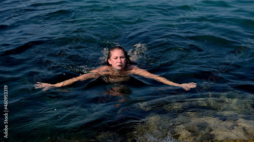 a girl tied with ropes floats in the water