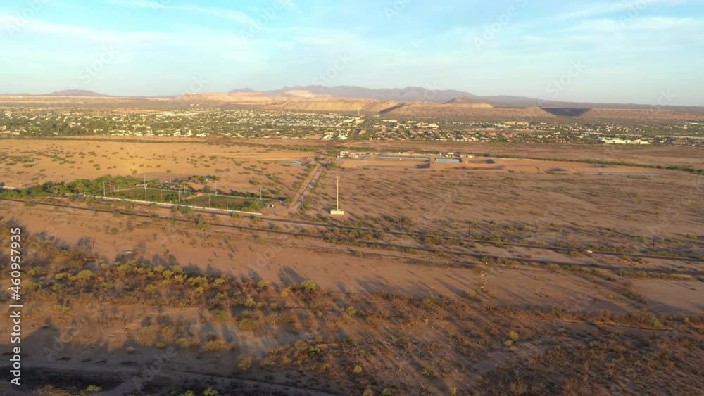 Aerial over brown fields at golden hour, Green Valley, Arizona in background Aerial over brown fields at golden hour, Green Valley, Arizona in background