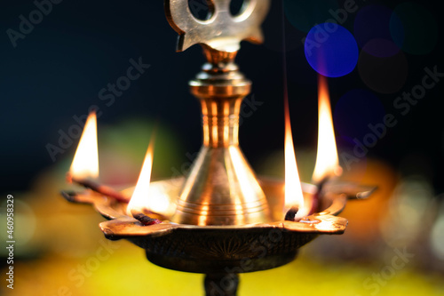 Closeup Of Golden Brass Panchmukhi Diya Deep Illuminated In Dark With Blur Bokeh Effect Background For Diwali Puja New Year Deepawali Or Shubh Deepavali Navratra Pooja Festival Celebration photo
