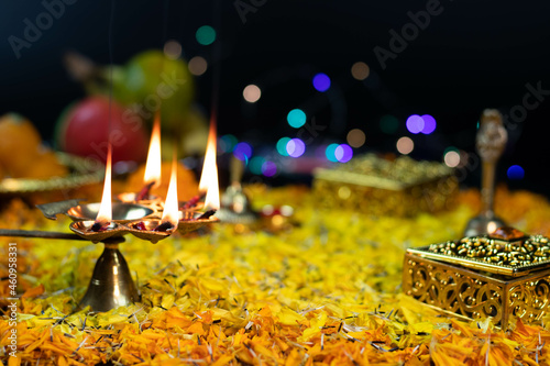 Panchmukhi Golden Brass Diya Deep Illuminated On Flower Bed Decoration And Bokeh Effect For Diwali Puja New Year Deepawali Or Shubh Deepavali Navratra Pooja Festival Celebration. Selective Focus photo