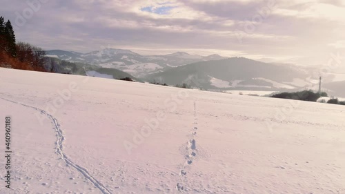 Aerial low angle towards traces on white Snow, Mountains as background - Slovakia photo