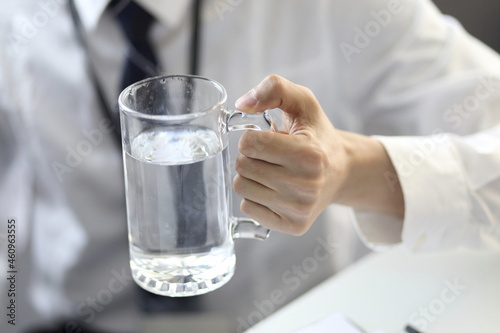 Businessman drinking glass of water at desk
