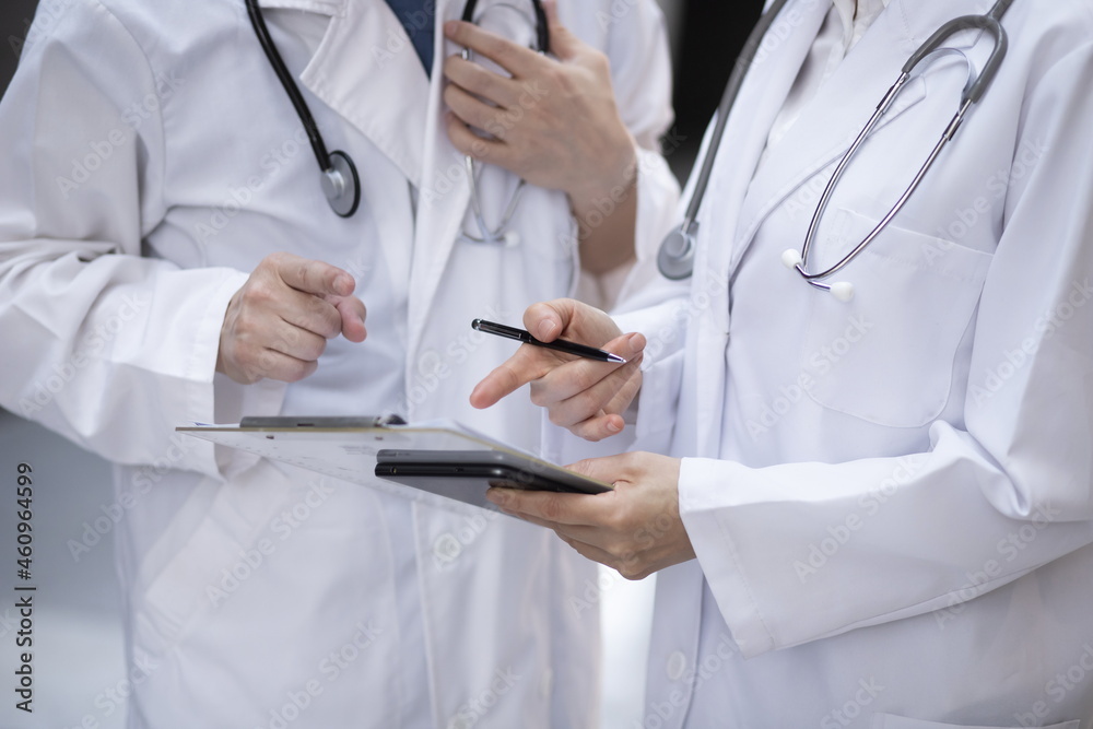 Doctors reviewing medical charts in meeting Doctors reviewing medical charts in meeting