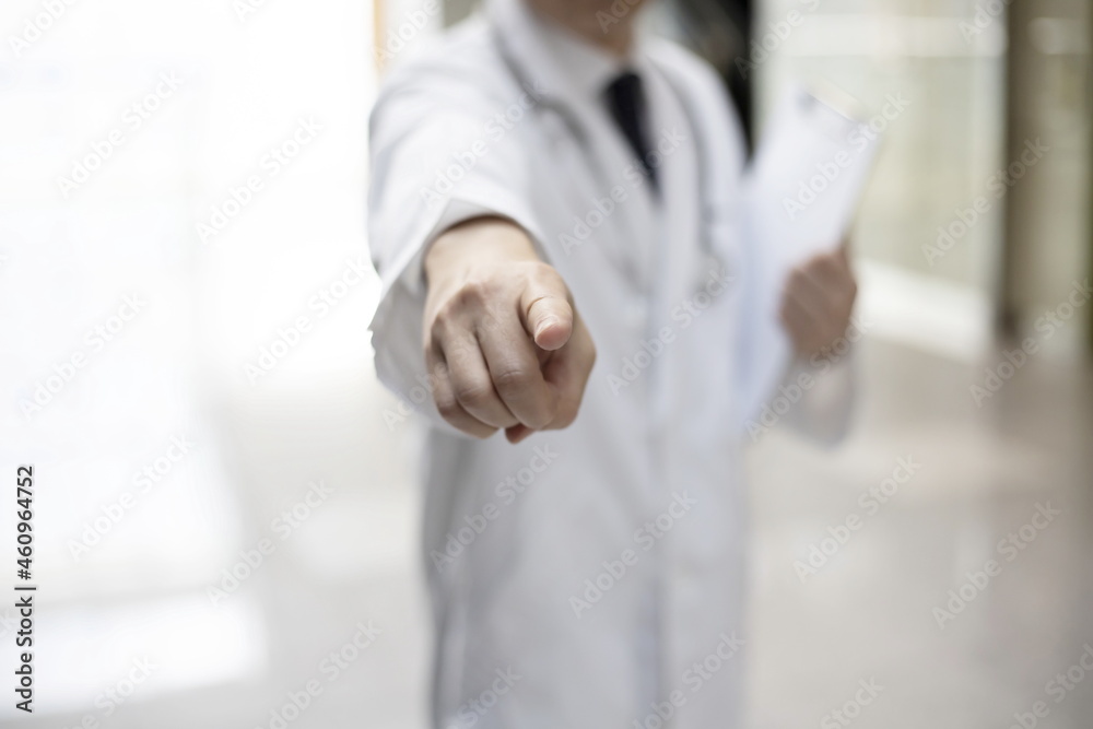 Confident doctor showing pointing finger forward Confident doctor showing pointing finger forward