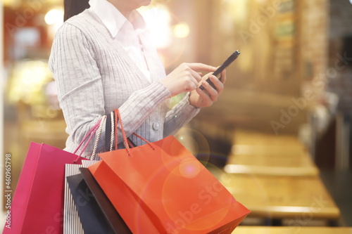 Woman with shopping bags using mobile phone 