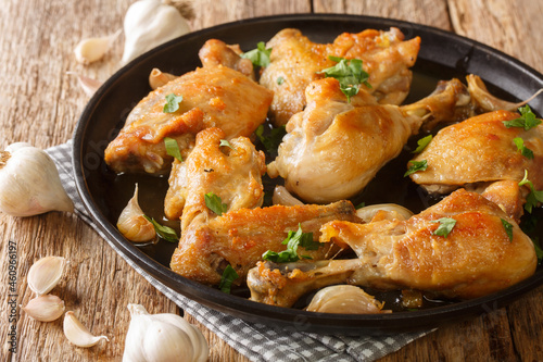 Chicken Cooked with bay garlic and white wine pollo al ajillo is a delicious dinner close-up on a plate on the table. Horizontal