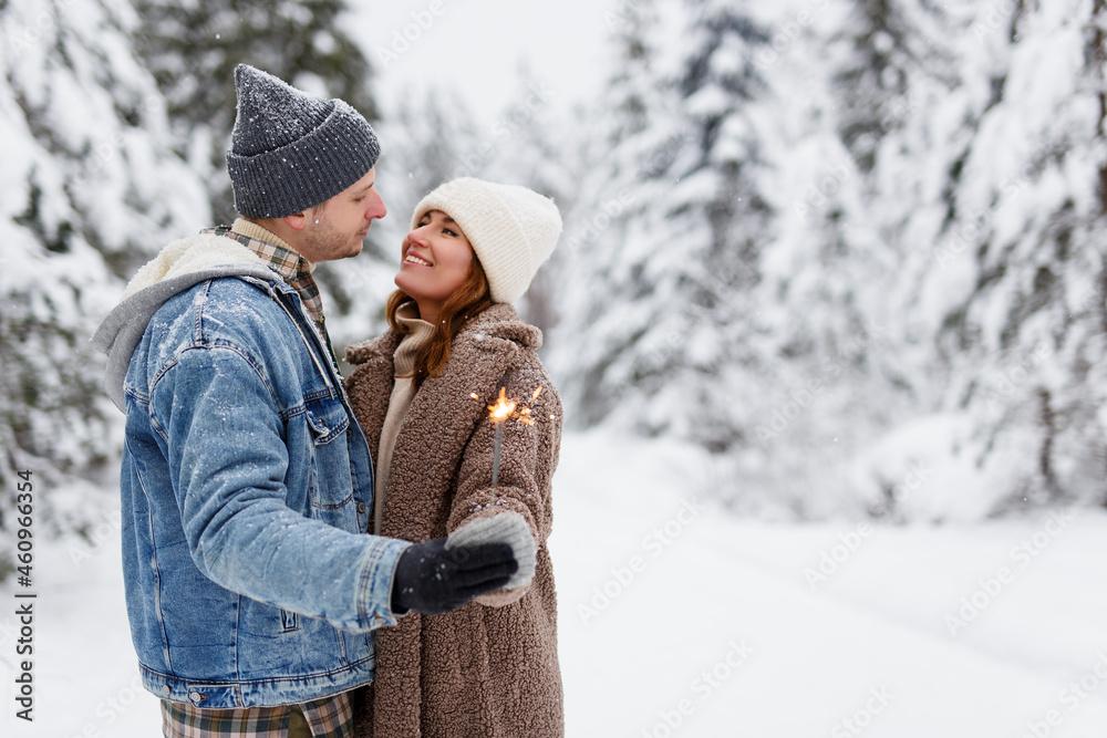 cute couple posing with sparklers in winter forest. cute couple posing with sparklers in winter forest.