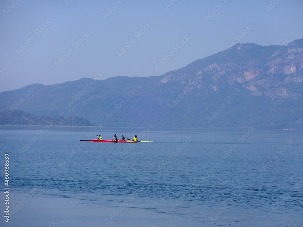 Fototapeta premium Calm surface of the lake and sportsmen on a kayak
