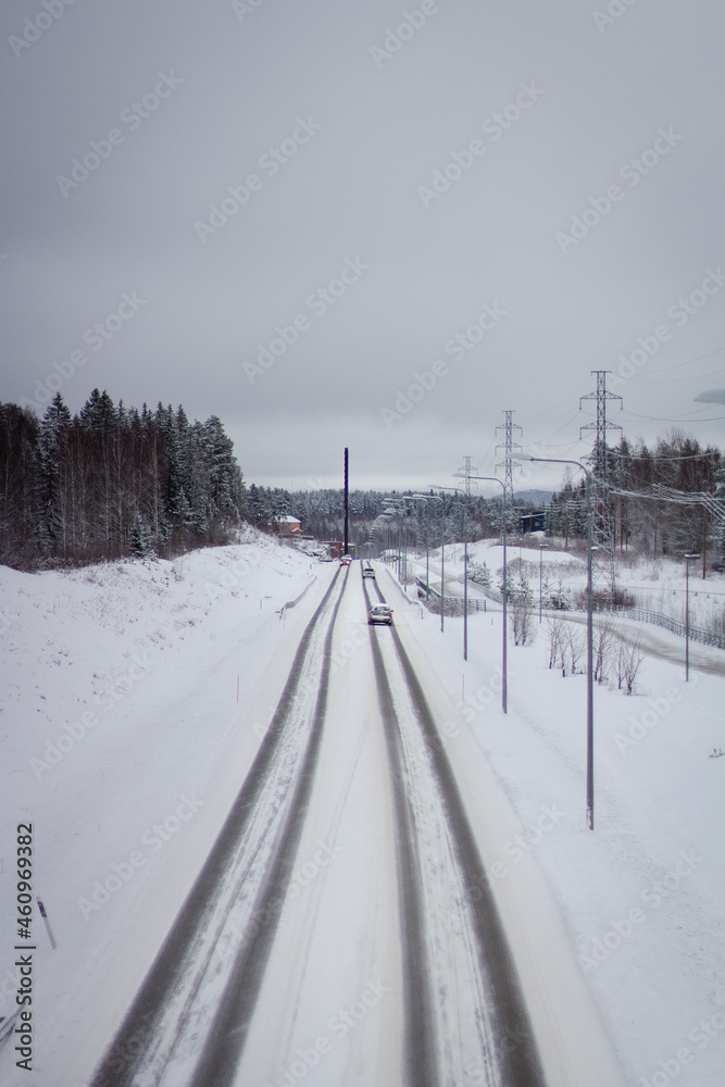 tire tracks on a road covered in snow in a rural area in Finland 