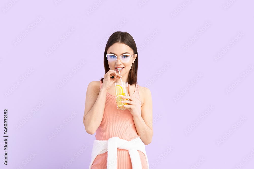 Beautiful young woman drinking fresh lemonade on color background Beautiful young woman drinking fresh lemonade on color background