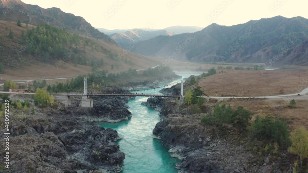 The turquoise Katun River flows among the mountains and fields along the Altai Mountains in autumn colors The turquoise Katun River flows among the mountains and fields along the Altai Mountains in autumn colors