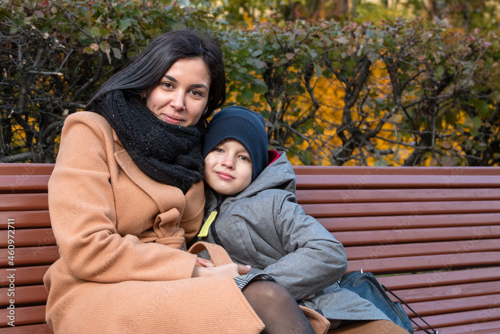 Young mom with her son hug on the bench. Young mom with her son hug on the bench.