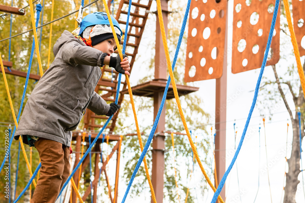 Little boy plays in the rope park.