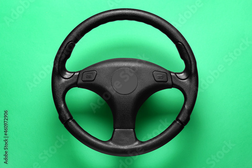 Black modern steering wheel on green background
