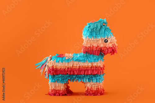 Mexican pinata in shape of horse on orange background photo