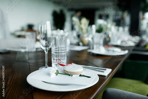 Beautiful decoration of a festive table with crockery and cutlery, decorated with flowers and ribbons. Festive table setting.