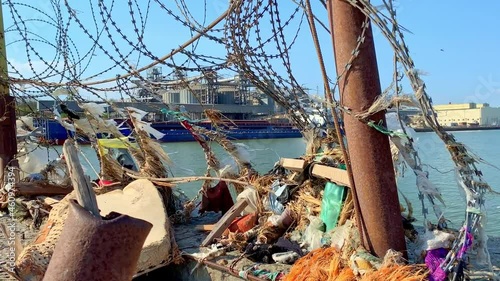 Port pier Water area of the Taganrog Bay. Marine debris on a barbed wire fence. Environmental pollution. Environmental action. photo