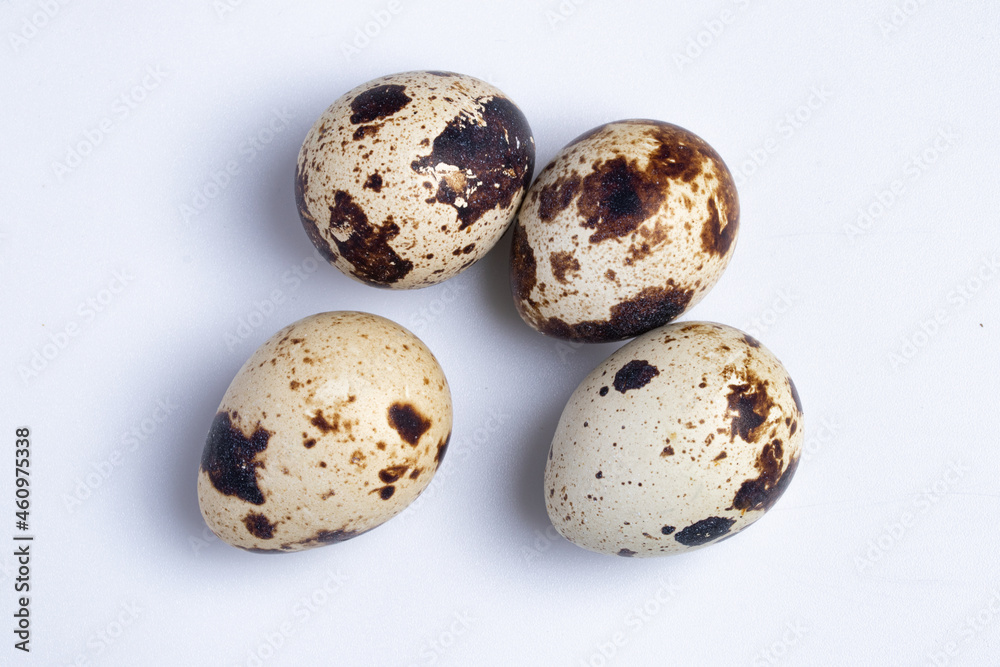Quail eggs in a wooden cup on a white background