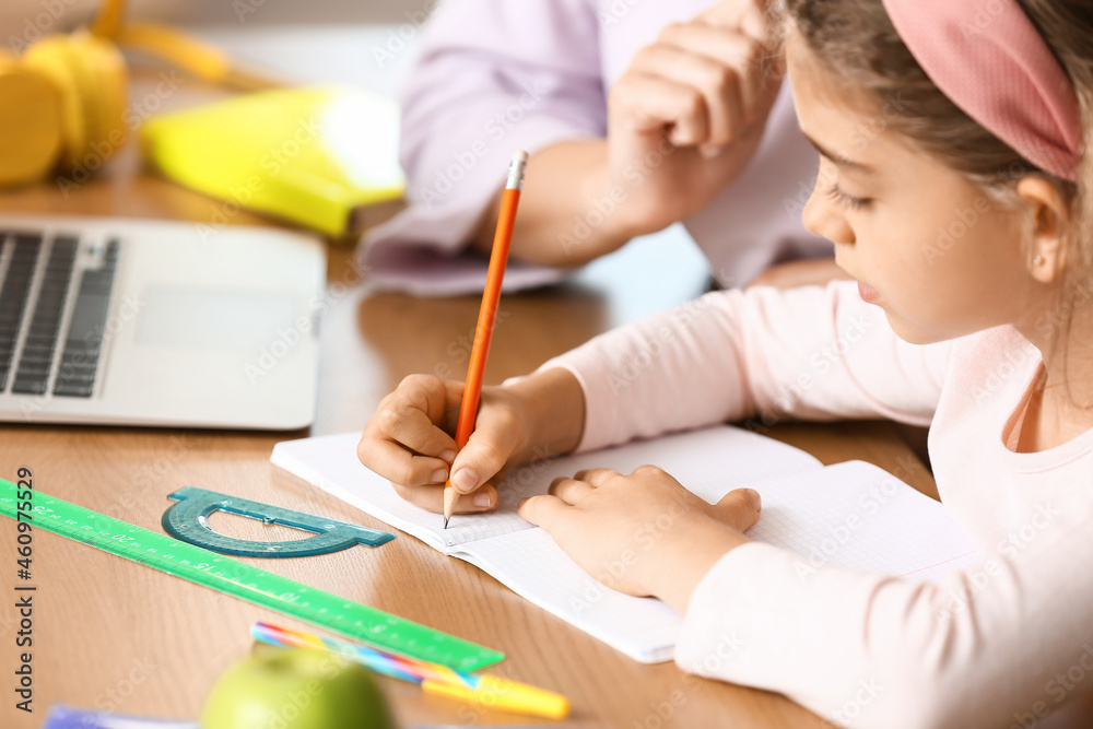 Little girl with her mother doing lessons at home Little girl with her mother doing lessons at home