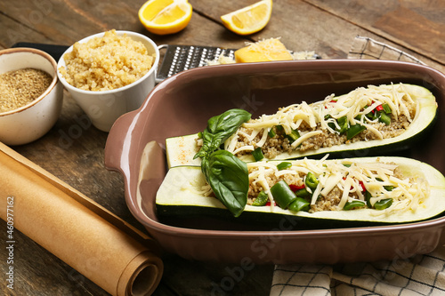 Composition with quinoa stuffed zucchini boats on wooden background