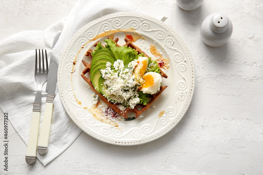 Delicious Belgian waffle with egg, cheese and avocado on light background Delicious Belgian waffle with egg, cheese and avocado on light background
