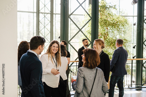 Smiling male and female entrepreneur discussing while standing at convention center