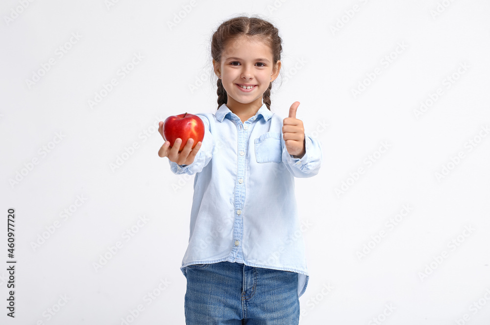 Little girl with apple showing thumb-up on white background Little girl with apple showing thumb-up on white background